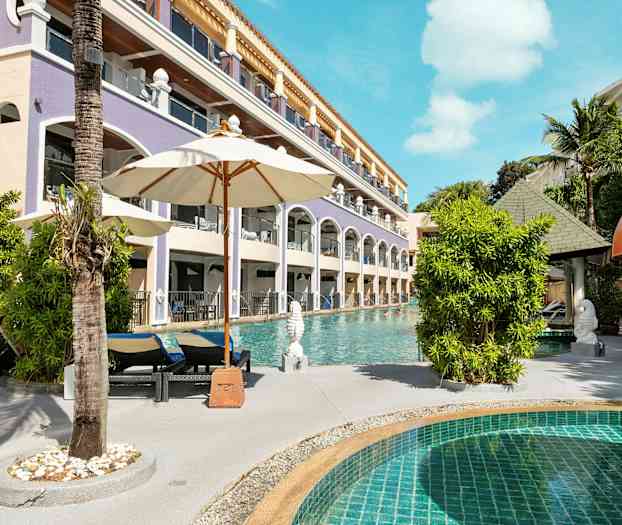 En pool med solstolar och parasoller nära en hotellbyggnad. (AI-genererad text)