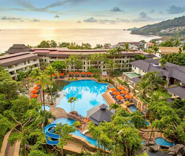 Hotellområde med pool och omgivande trädgård, beläget nära havet. (AI-genererad text)