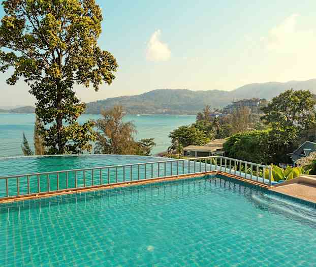 Utsikt över pool med hav och berg i bakgrunden. (AI-genererad text)