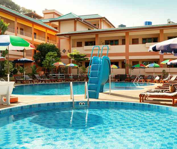 Hotellpoolområde med solstolar och parasoller. (AI-genererad text)