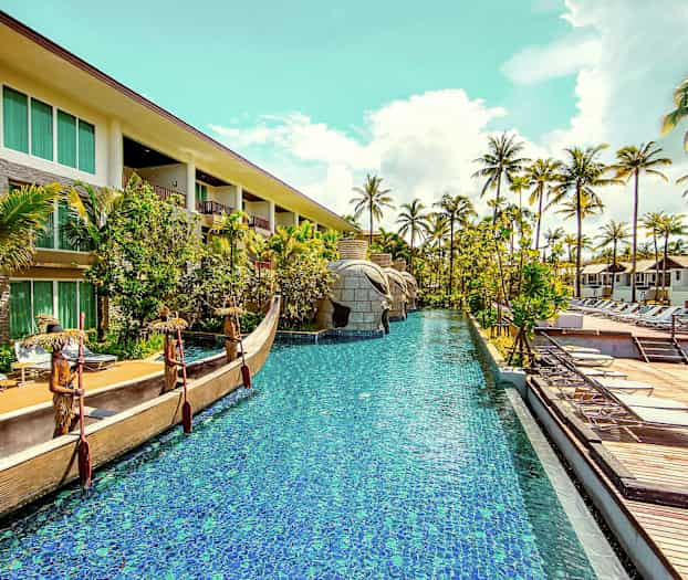 Hotellområde med swimmingpool, omgiven av palmer och solstolar. (AI-genererad text)