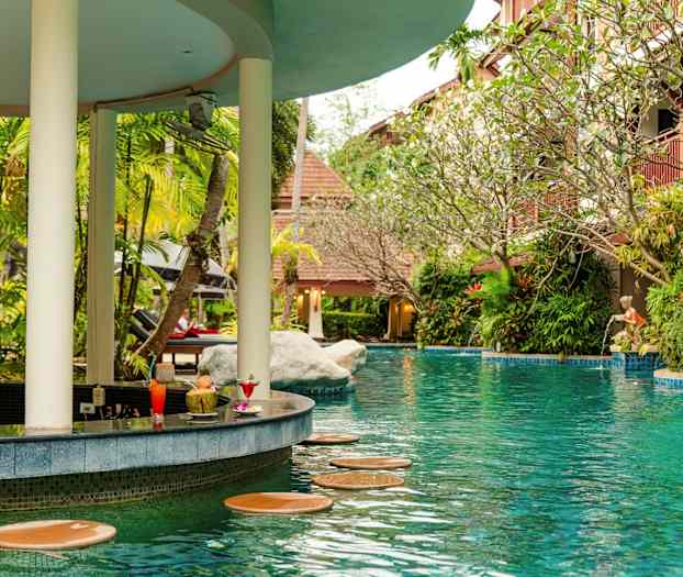 En pool med ett barområde omgivet av grönska. (AI-genererad text)