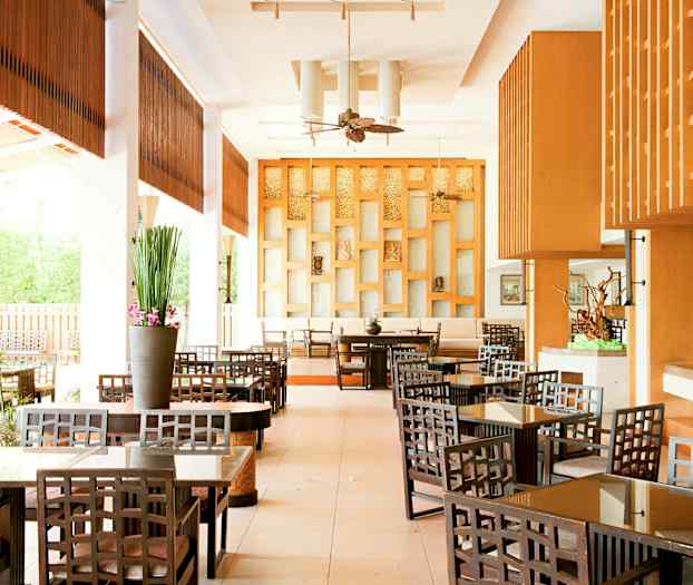 Ett elegant hotellcafé med trämöbler och modern inredning. (AI-genererad text)