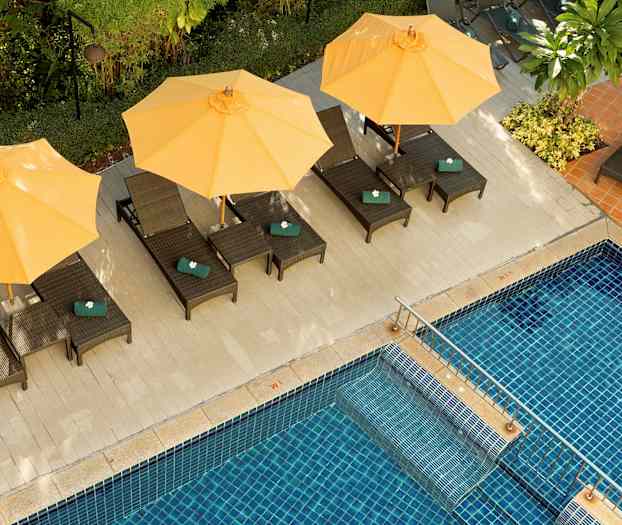 Solstolar med gula parasoller vid en pool. (AI-genererad text)