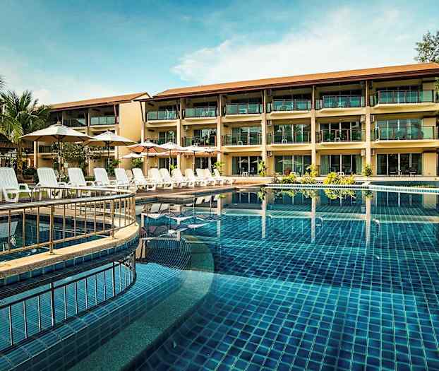 Ett hotell med tre våningar vid en pool med solsängar och parasoller. (AI-genererad text)