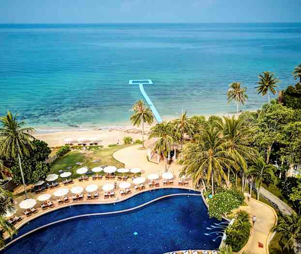 Bild av en pool omgiven av solstolar och parasoll, med utsikt över en strand och havet. (AI-genererad text)