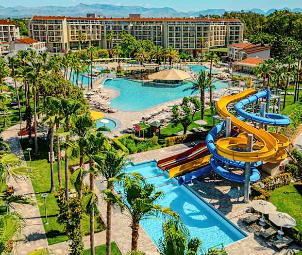 En resort med flera pooler, grönområden och vattenrutschkanor. (AI-genererad text)