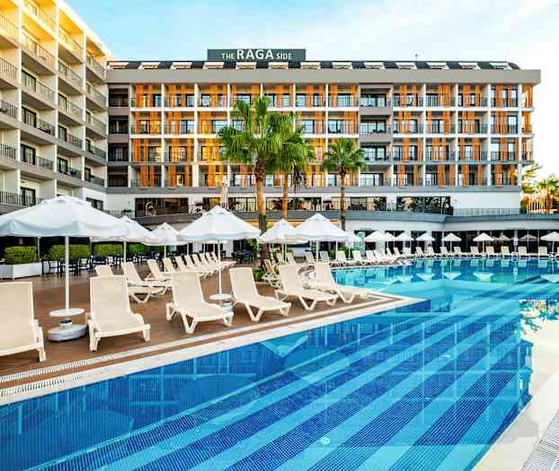 Ett hotell vid en pool med solstolar och parasoller. (AI-genererad text)