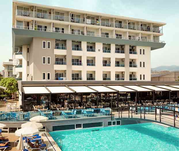 Vy av hotellbyggnad och utomhuspool. (AI-genererad text)