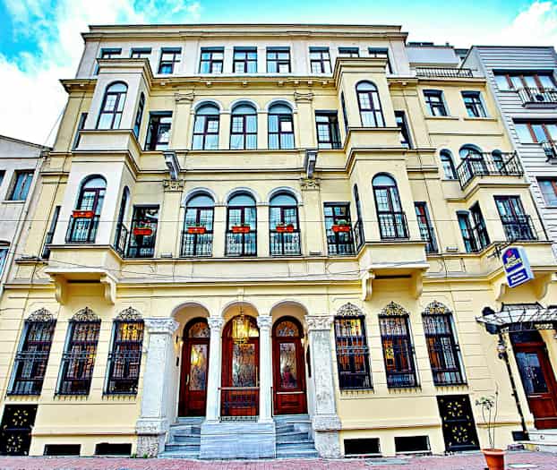 Fasad av en äldre byggnad med balkonger och dekorerade fönster. (AI-genererad text)