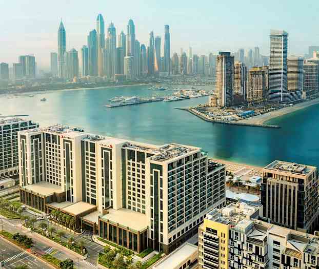 Stadsvy över moderna byggnader och en hamn vid vattnet. (AI-genererad text)