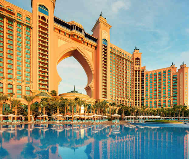 Stor byggnad med valv och pool framför. (AI-genererad text)