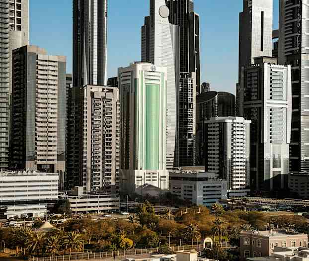 Höga moderna byggnader omgivna av grönska och parker. (AI-genererad text)