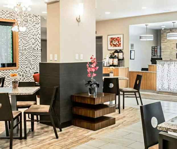 En hotellobby med sittplatser, dekorationer och receptionsområde. (AI-genererad text)