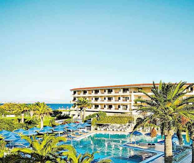 Hotellbyggnad med flera våningar omgiven av palmer och en stor pool. (AI-genererad text)