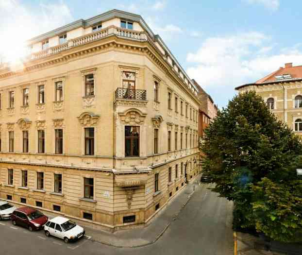 Gatlyktorna står vid en grönskande plats som omges av höga byggnader. (AI-genererad text)