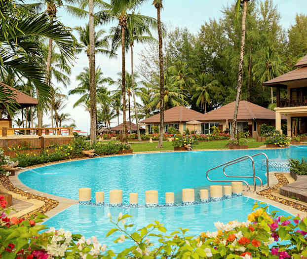 Resortområde med pool, omgivande trädgård och palmer. (AI-genererad text)