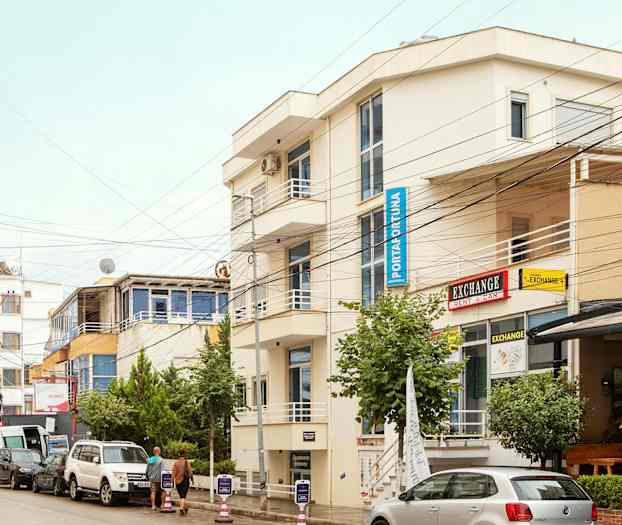 Gata med parkerade bilar och byggnader med skyltar. (AI-genererad text)