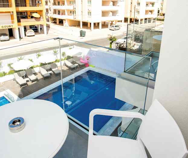 Balkong med utsikt över en pool och grannbyggnader. (AI-genererad text)