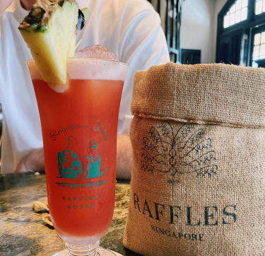 Den ikoniska drinken Singapore Sling på Long Bar (Raffles Hotel)