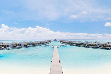 Water villas på lång rad i det turkosa havet på Maldiverna.