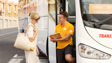 Guide hjälper gäst vid buss