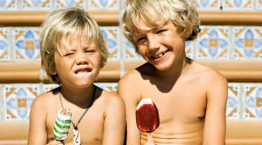 Två pojkar sitter på en trappa och äter glass