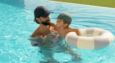 Pappa och son badar i en pool