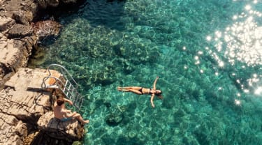 Tjej badar i havet i Kroatien