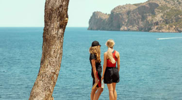 Två tjejer står och kollar ut över havet