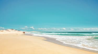 Strand med klarblått hav och himmel