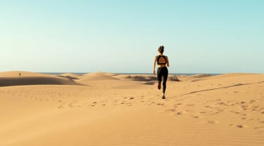 Kvinna som springer i öken