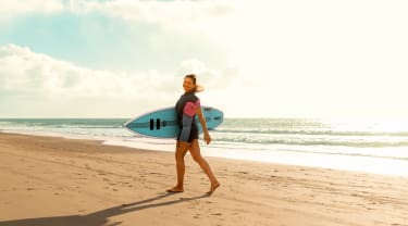 Tjej surfar på stranden