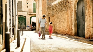 Pappa och dotter vandrar på en gata