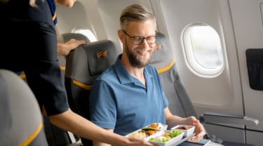 Man får mat serverad ombord på Sunclass Airlines