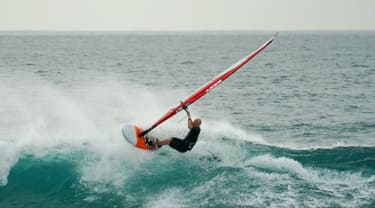 Surfare på vindsurfingbräda