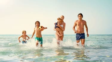 Familj som springer i vattnet