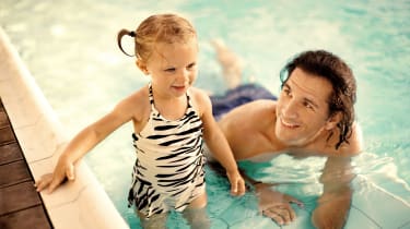 Pappa och dotter badar i en pool