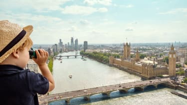 Pojke kikar ut över London med en kikare