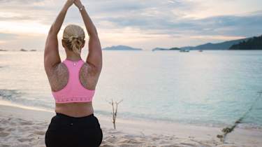 kvinna gör yoga ute på en brygga