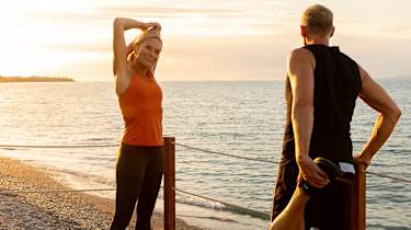 kvinna gör yoga ute på en brygga