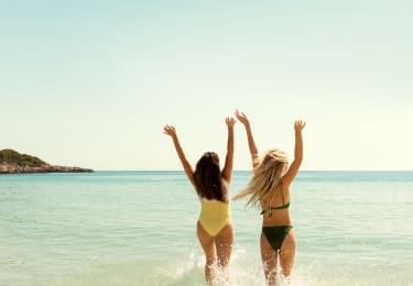 Två tjejer springer ut i vattnet