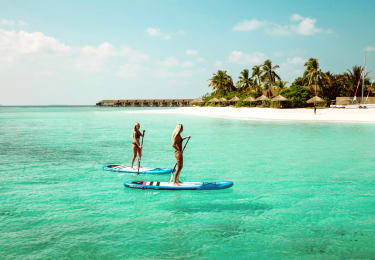 Två personer på padelbord på en ö i Maldiverna