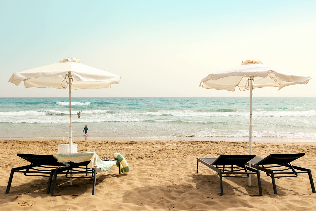 På stranden nedanför hotellet finns solstolar och parasoll att hyra.