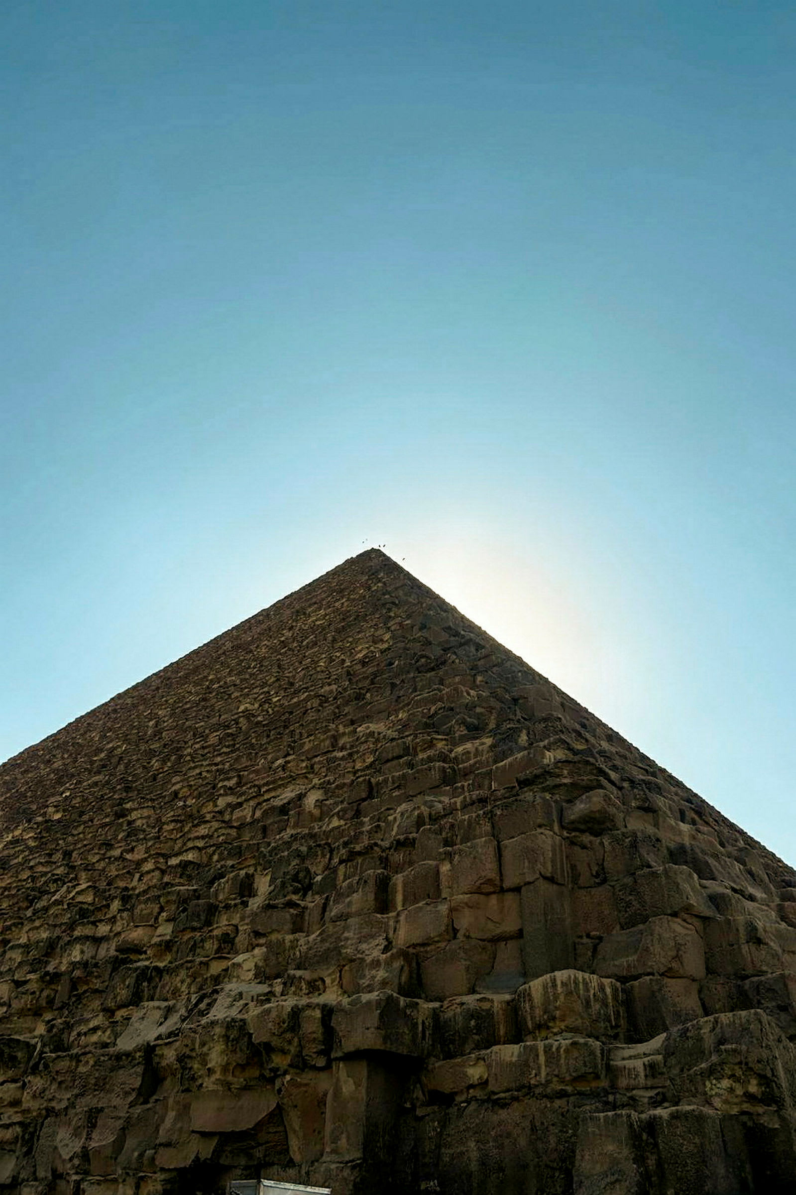 En pyramid i sten som sträcker sig uppåt mot en klar himmel. (AI-genererad text)