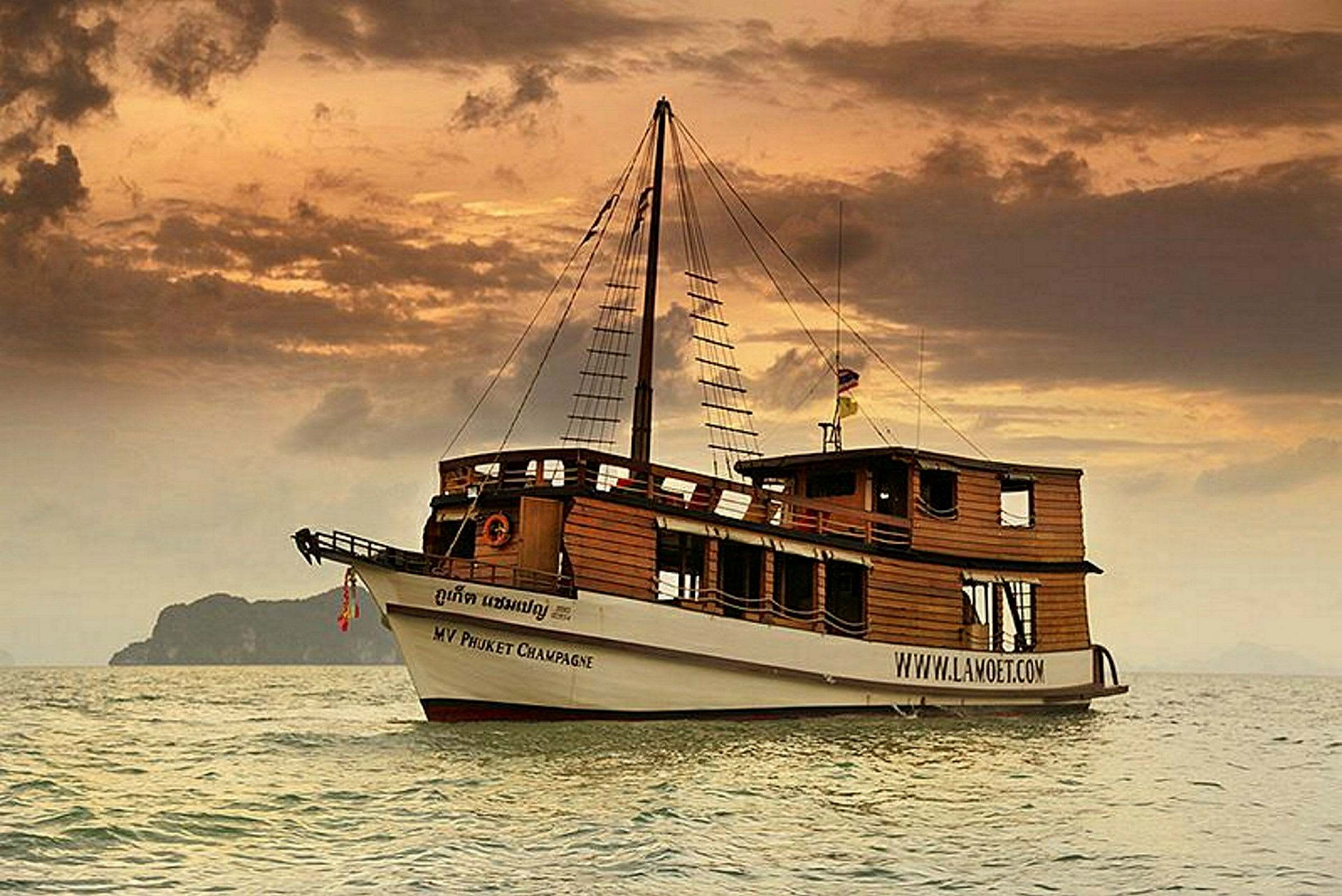Ett traditionellt träfartyg med seglarstruktur visas på havet vid solnedgången. (AI-genererad text)
