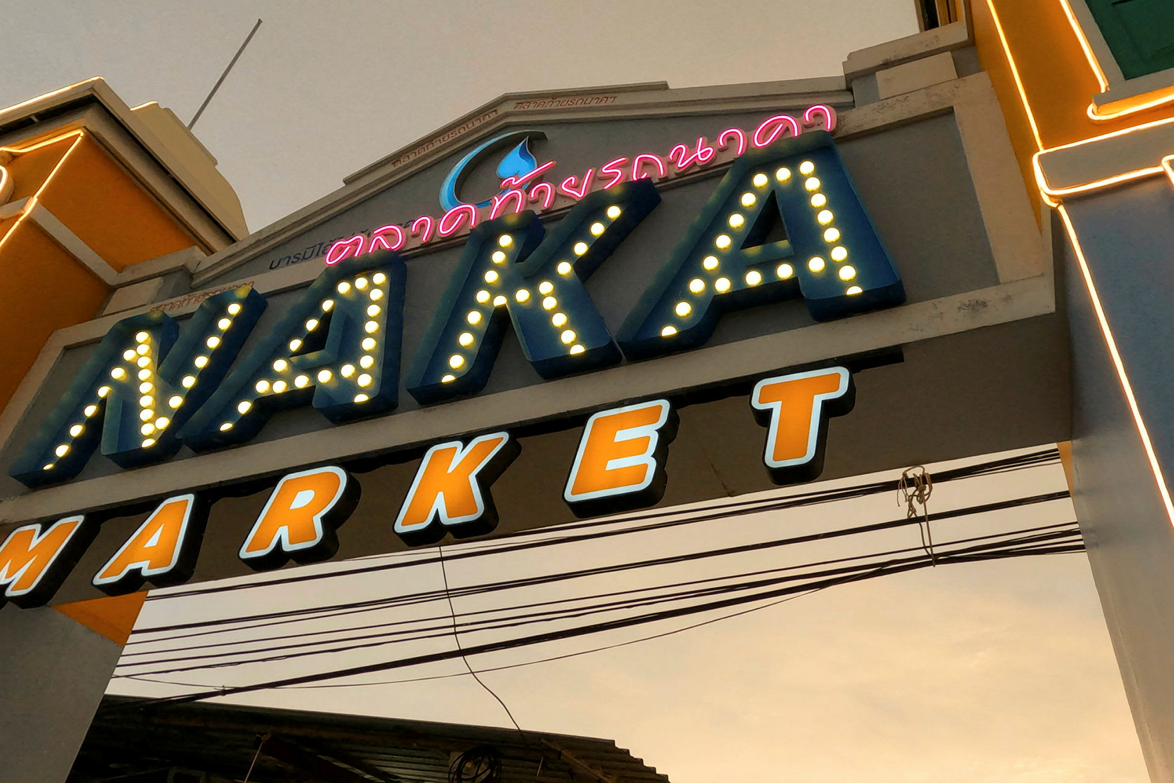Entrén till Naka Market med belysning och märkning. (AI-genererad text)