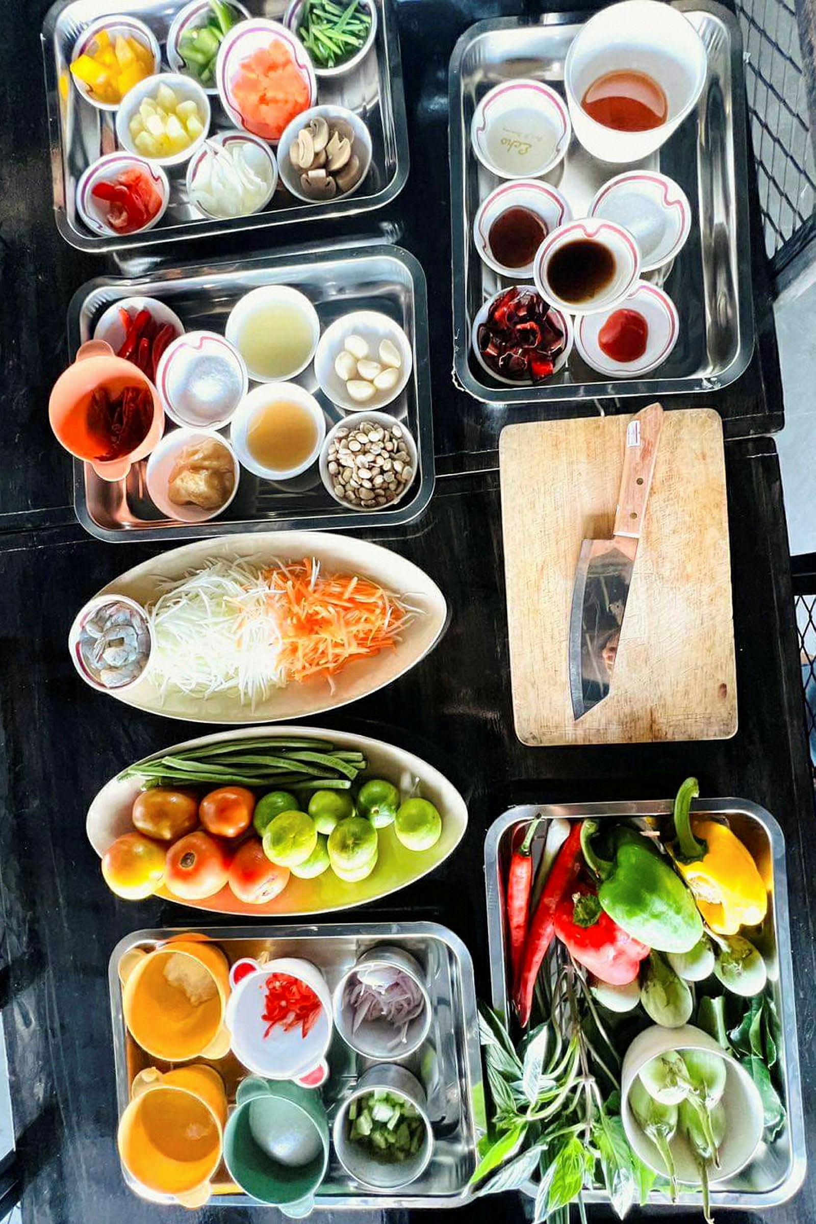 Olika grönsaker, kryddor och ingredienser arrangerade i skålar och fat på ett bord. (AI-genererad text)