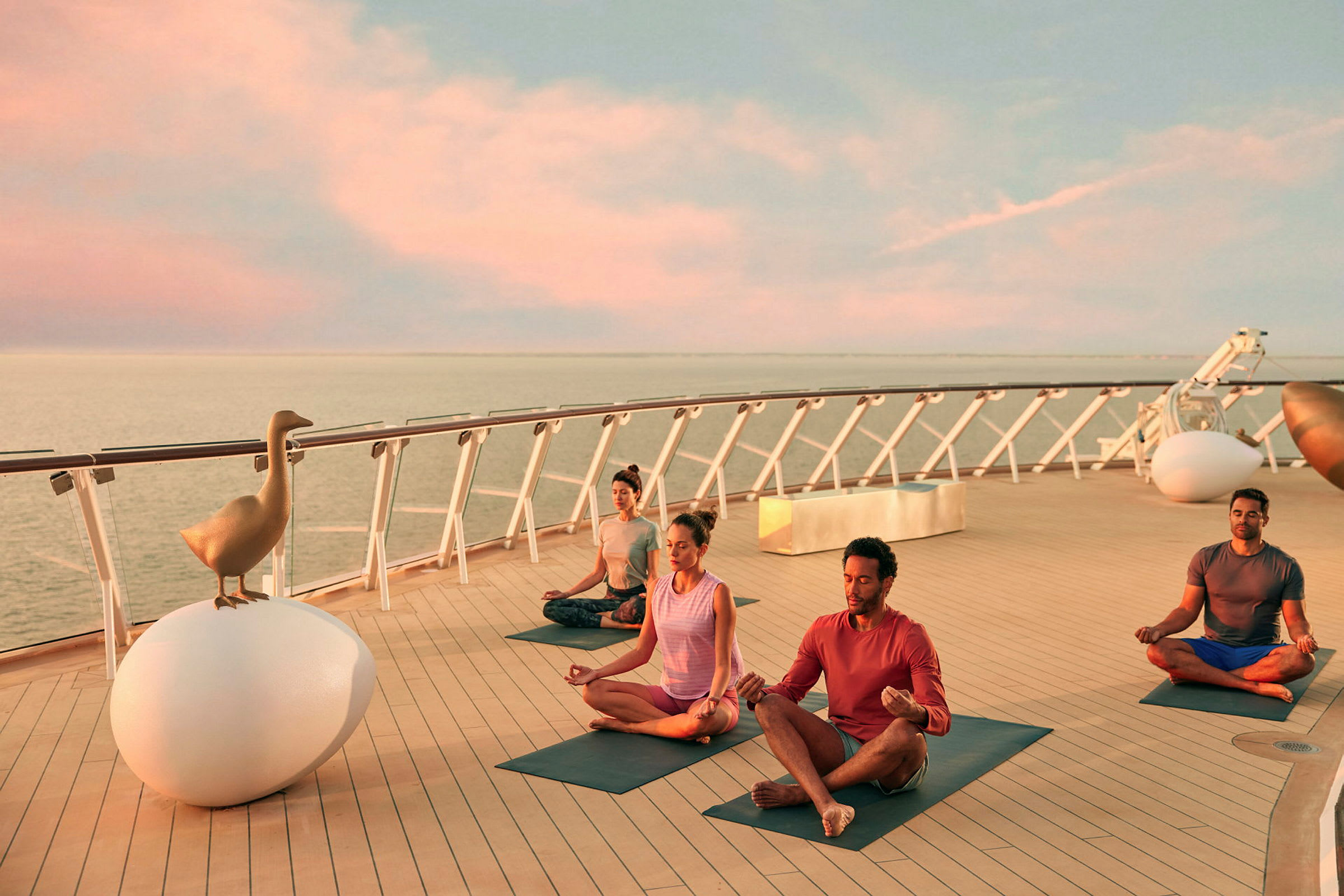 Personer som utövar yoga på en kryssningsfartygsdäck, vid havet vid solnedgång. (AI-genererad text)