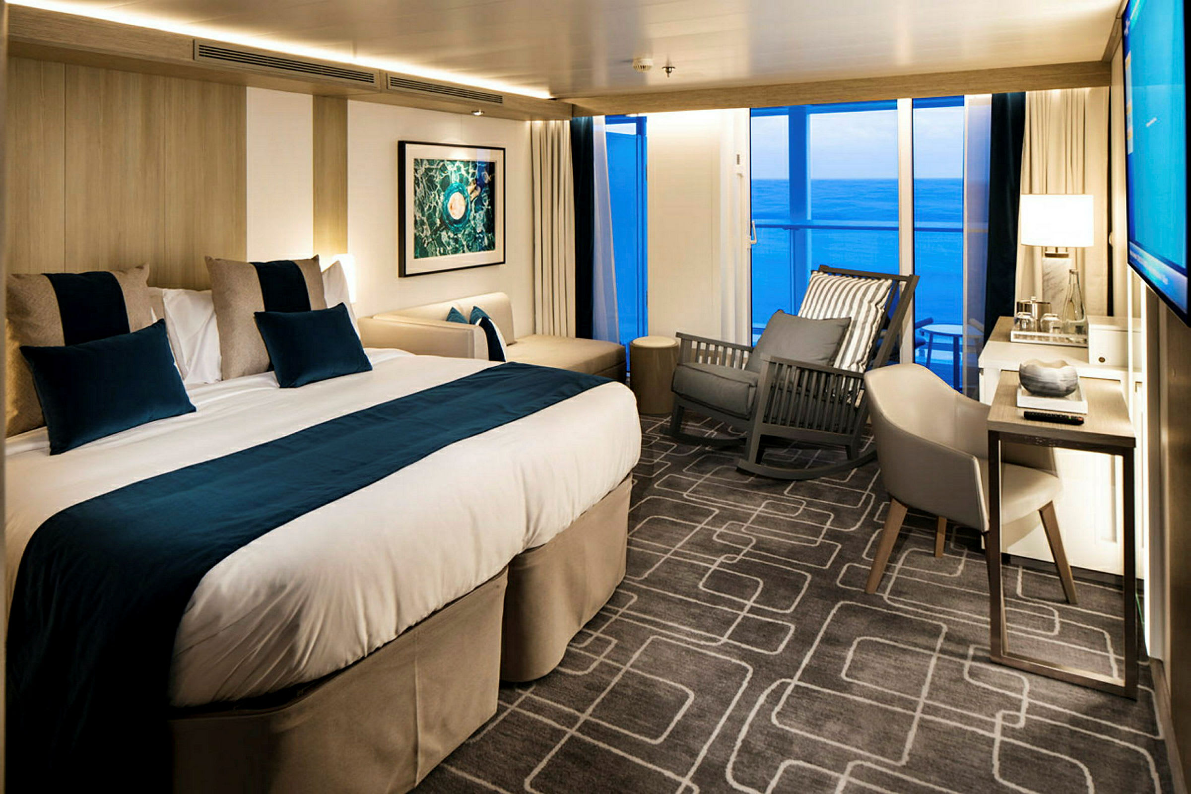 Hotellrum med dubbelsäng, stol och havsutsikt. (AI-genererad text)